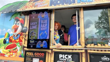 Workers smile through the window of the Kona Ice food truck on Rutgers Day