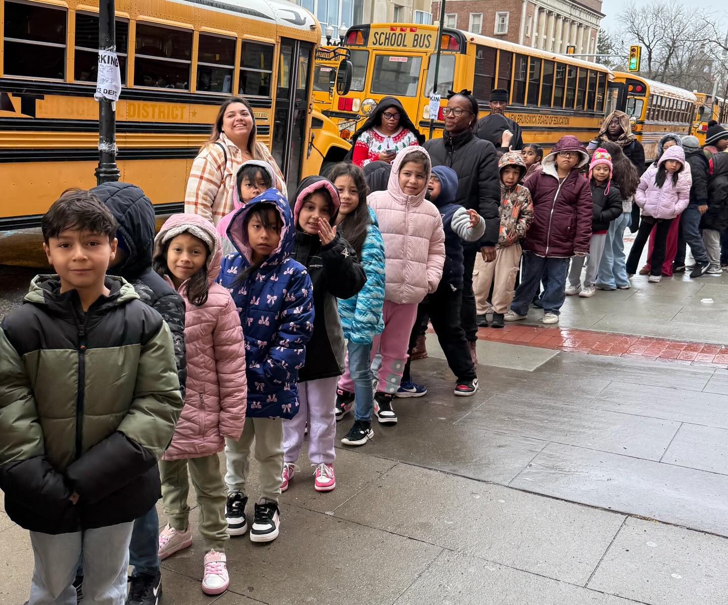 May be an image of standing, bus, school bus, park and text