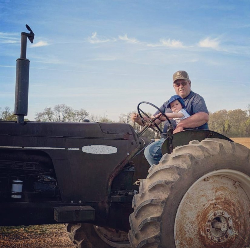 Man and baby riding on a tractor