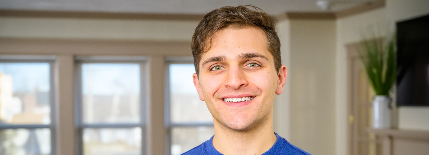 a patient smiling at the camera within the common area at Millbury, MA